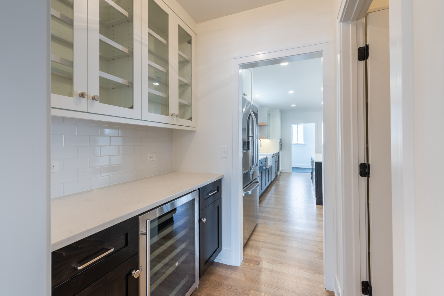 Custom home kitchen design - view of wine cooler and pantry - Platinum Builders