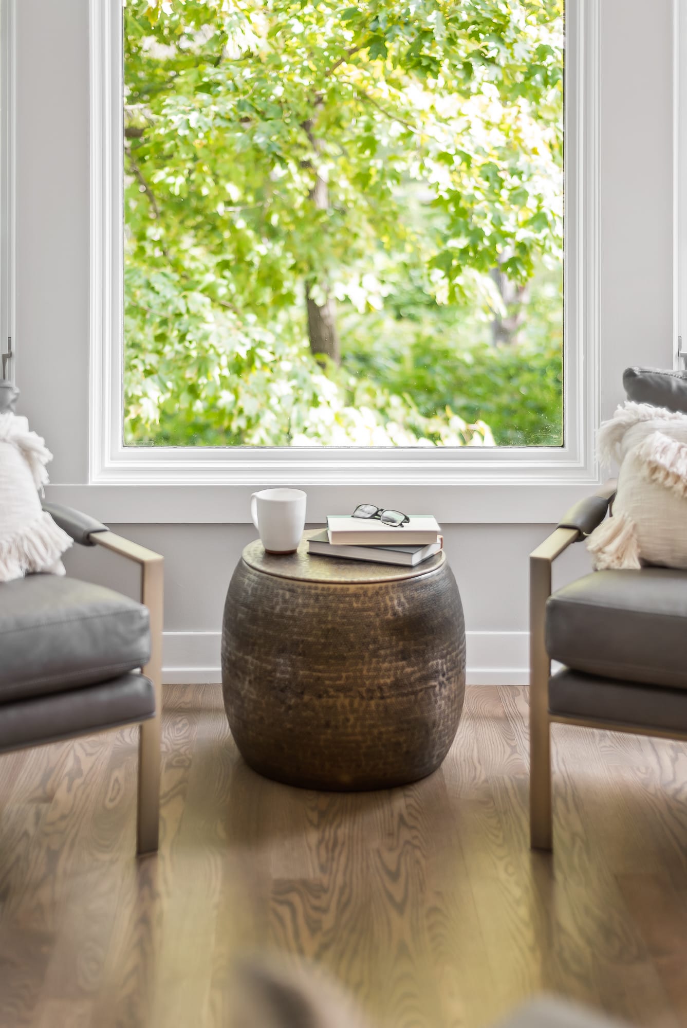 Living room remodel in Downers Grove - closeup of small table in front of floor to ceiling windows.