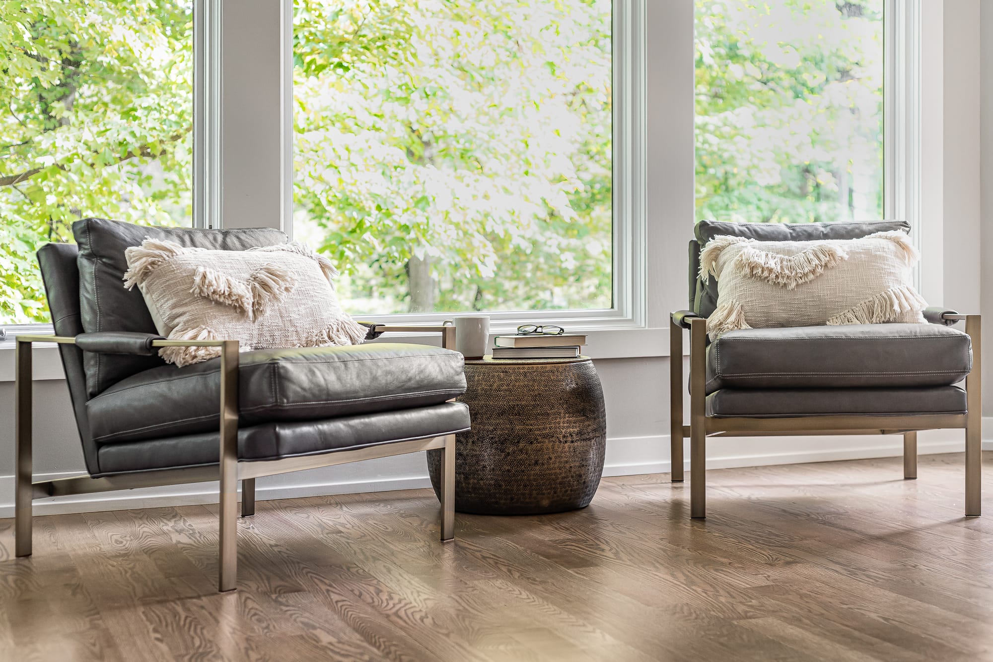 Living room remodel in Downers Grove - image of two reading chairs by large windows with small table placed in between the chairs.